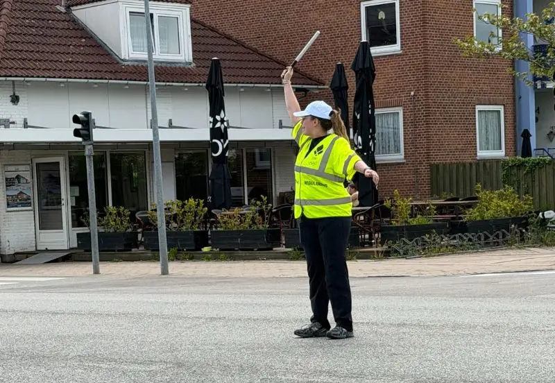 Trafikofficial i gul vest der regulerer trafik ved et arrangement